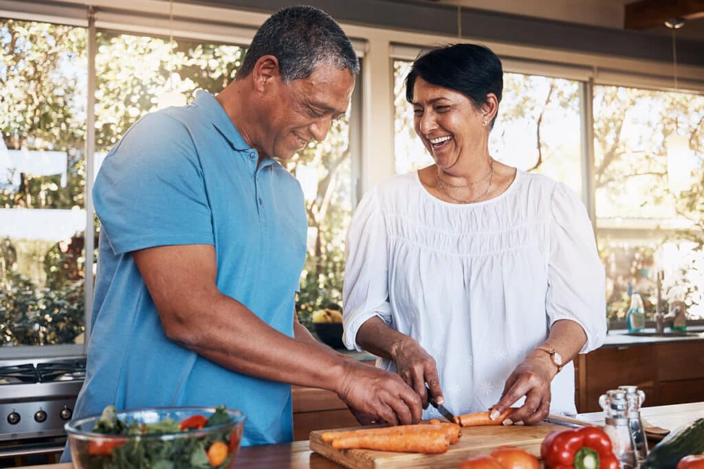Man and woman cutting carrots